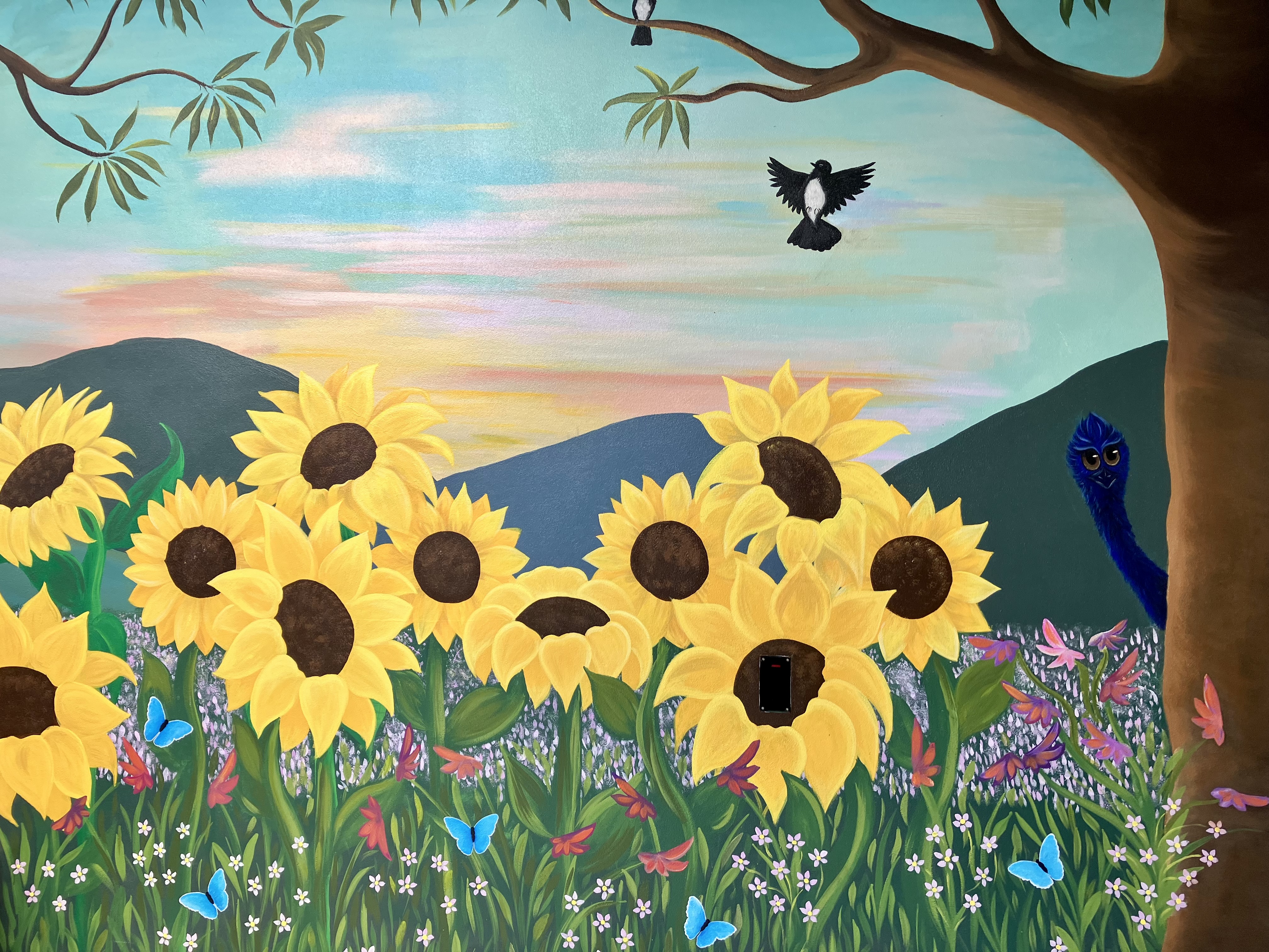 Nature-themed mural inside mental health pod featuring sunflowers