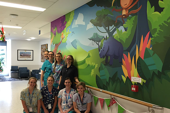 Staff of the children’s ward in front of one of the colourful, vibrant murals.